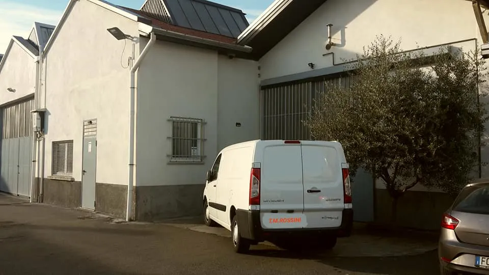 La fotografia mostra il portone dello stabilimento produttivo, e il furgone aziendale.