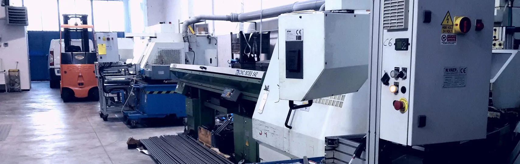 La fotografia mostra l'interno di uno dei due padiglioni di Torneria Rossini. Si possono vedere anche due torni CNC "Biglia" automatici da barra.